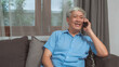 © tirachard - Asian senior man talk on phone at home. Asian senior older Chinese male using mobile phone talking with family grandchild kids while lying on sofa in living room at home concept.