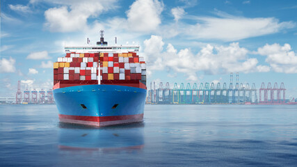 Front view from bow of a large blue shipping container ship with port harbour and container terminal on a horizon.