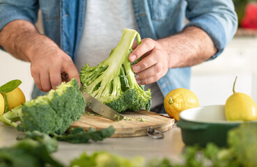 Canvas Print - Man preparing delicious and healthy dinner of broccoli at home kitchen