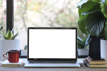 laptop mock up white blank screen with phone and coffee cup and plant pot on wooden table
