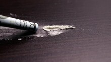 Dolly Moves From Left To Right Along A Line Of Cocaine Powder Sniffed Up By A Rolled-up Dollar Bill On A Dark Countertop. The Concept Of Addiction And Substance Abuse