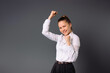 © Viorel - Young girl entrepreneur won the project. Rejoices at success on a gray background.