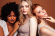 © iordani - young pretty caucasian, afro, scandinavian woman posing cheerful together on brown background, lifestyle diverse nationality people concept