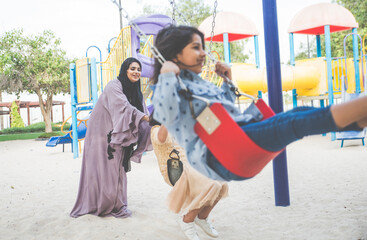 Wall Mural - Mom and daughters spending time together at the park, in Dubai