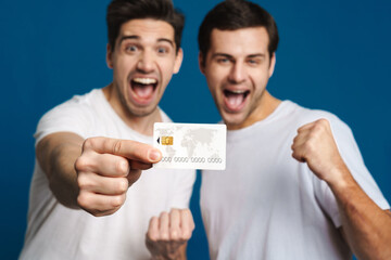 Excited two guys making winner gesture while showing credit card