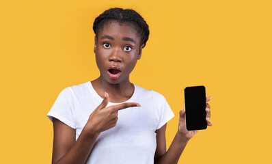 Aufkleber - Shocked African Woman Showing Phone Blank Screen On Yellow Background