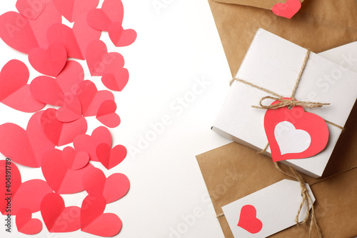 White gift box, gift and envelope wrapped in brown craft paper, tied with twine with bows and labels with red paper hearts. Love, Valentine's, mother's, women's day, relations, romantic template 