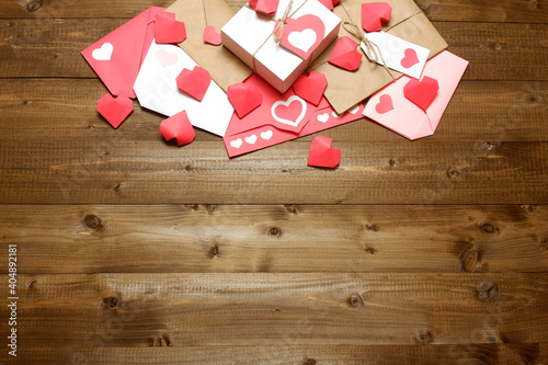 Love, Valentine's, women's day, relations, romantic template from gifts and love letters, colored and wrapped in craft paper, tied with twine with bows and labels, hearts on wood background 