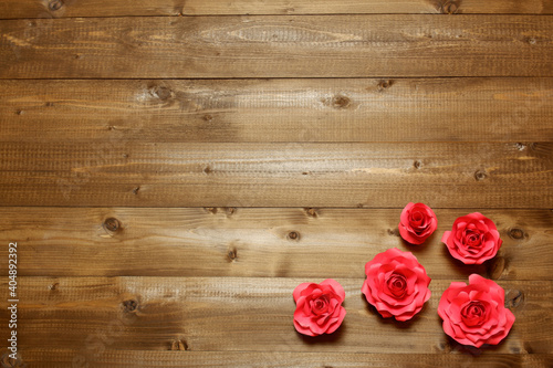 Few handmade red paper roses on brown wooden planks background. Love, Valentine's, mother's, women's day, relations, romantic, wedding template 