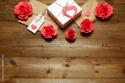 Love, Valentine's, women's day, relations, romantic template with gifts and envelope, wrapped in brown craft paper, tied with twine with bows, labels, 3D handmade paper roses on wooden boards 