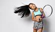 Young asian girl preteen big tennis player with racket in motion studio shot portrait on copy space. Beautiful sportive female child with oriental appearance and sportswear looking at camera