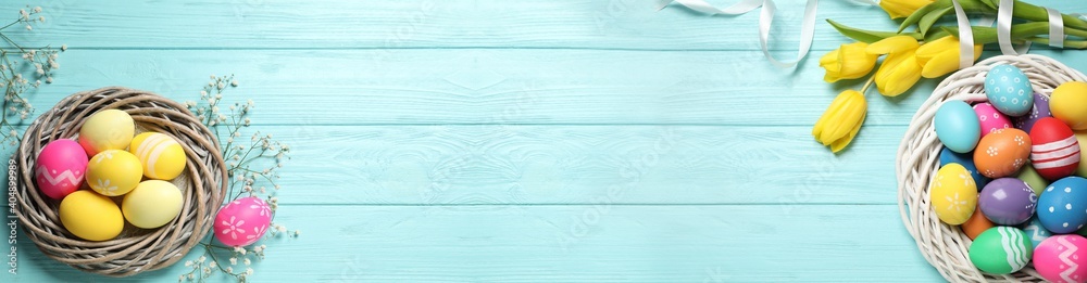 Flat lay composition with colorful Easter eggs and tulip flowers on light blue wooden background, space for text. Horizontal banner design - obrazy, fototapety, plakaty 