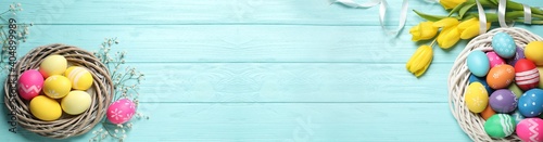 Obraz Dibond Flat lay composition with colorful Easter eggs and tulip flowers on light blue wooden background, space for text. Horizontal banner design