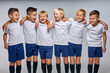 © Roman - kids soccer players celebrate a winning in school sports tournament, studio portrait of happy joyful kids in uniform engaged in football