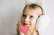 Cute blue-eyed little girl holding pink heart for valentines day. Lovely smiling child with heart. Hipster. Love.