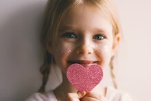 Cute Blue-eyed Little Girl Holding Pink Heart For Valentines Day. Lovely Smiling Child With Heart. Hipster. Love.