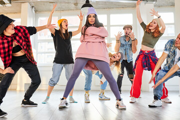 female dance teacher recording a new dance video in studio with pupils, dancers having a rehearsal together