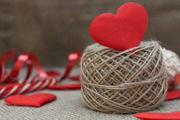 Red hearts and jute thread on a beige background