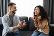 © Kateryna - Marriage proposal. A surprise for beloved woman. A guy gives an engagement ring to his beloved african american girl, she gladly accepts it. Happy couple in love