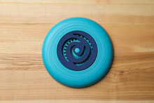 Blue Plastic Frisbee Disk On Wooden Background, Top View