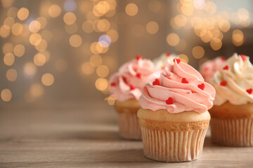 Tasty sweet cupcakes on wooden table, space for text. Happy Valentine's Day