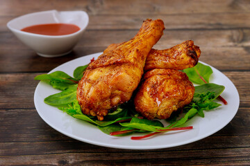 Roasted chicken legs with sauce on rustic wooden background,