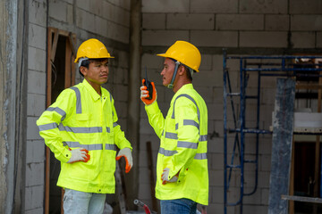 Poster - Construction worker wearing safety clothing and discussing on construction site.