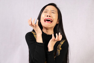 Young attractive southeast Asian woman posing facial expression cry upset shout