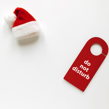 High Angle View Of Do Not Disturb Sign And Santa Hat On White Background