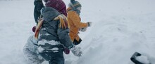 HANDHELD Group Of Kids Having Snowball Fight Brawl, Hiding Behind The Snow Fort Wall. Fun Winter Games Outside. 120 FPS Slow Motion Shot