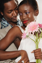 African Couple Hugging And Holding Daisies