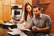 © SuperStock - Hispanic couple looking at paperwork in kitchen