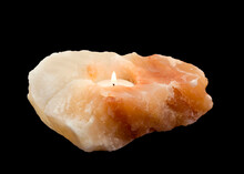 Burning Tea-light Candle In A Salt Stone Holder On Black Background
