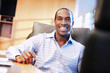 © SuperStock - Smiling African American businessman sitting at desk