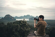 © oatawa - Man traveler take photo view of mountain with dslr camera.
