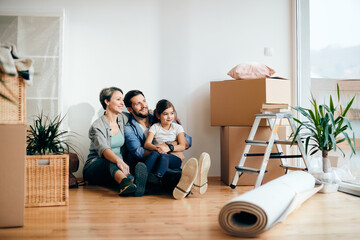 Wall Mural - Happy family relaxing on the floor at their new home.