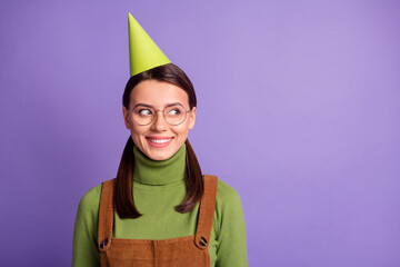 Wall Mural - Close-up portrait of cute curious cheerful girl wearing paper cap looking aside copy space isolated over bright violet color background