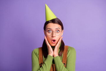 Wall Mural - Close-up portrait of lovely amazed girl wearing celebratory paper cap pout lips wow isolated over bright violet color background