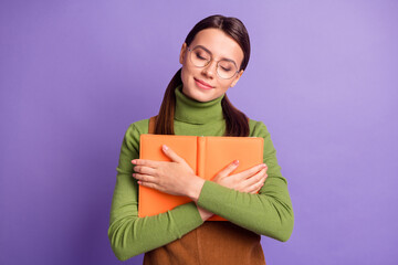 Wall Mural - Portrait of pretty dreamy cheery girl embracing holding book diary isolated over bright violet color background