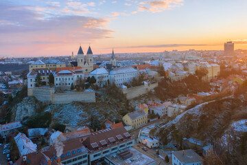Wall Mural - Veszprém, Hungary - Amazing aerial view of Veszprém downtown and castle district on a winter morning with stunning golden sunrise. Historical old buildings, church and much more.