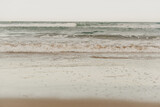 Fototapeta Morze - Front view of the beach with brown sand and the blue sea with waves in the coast of Spain in Tarragona