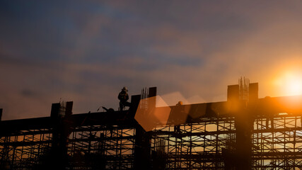 Wall Mural - Silhouette Engineer and construction team working at site over blurred  industry background with Light fair Film Grain effect.