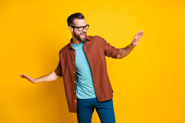 Sticker - Photo of charming funky optimistic young man raise hands look dance free-time isolated on yellow color background