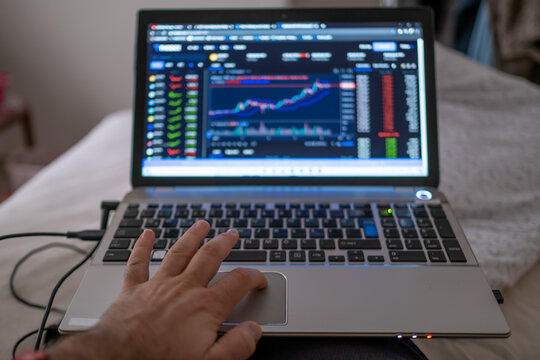 Man viewing graphics with a leptop from the bed.