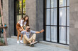 © NVB Stocker - Happy Hipster couple skateboard and skates extreme sports on street in the city. hipster man sitting on skateboard and woman couple pull and go.