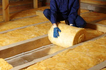 Wall Mural - Worker thermally insulating house attic with glass wool