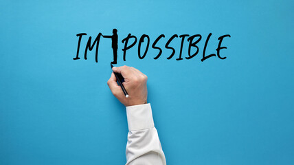 Wall Mural - Male hand drawing a businessman silhouette, transforming the word impossible into possible by pushing away the letters.