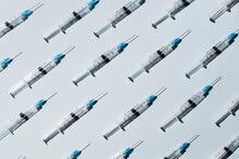 COVID-19 Vaccine Syringes On Blue Background
