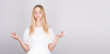 © Studio Nova - Calm, relaxed pretty blonde relieves stress, closes her eyes and smiles peacefully, meditating with her arms outstretched in mudra, Zen, standing in Lotus position, practicing yoga, gray background