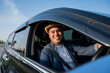 © Chanakon - A young Asian man drives a car on a clear day. With beautiful blue sky. He driving to travel by car.